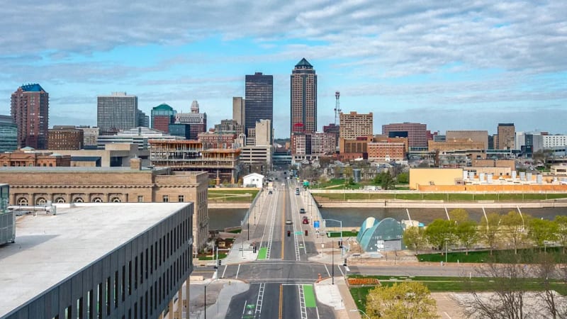 Diverse people walking, biking, and using wheelchairs on a well-designed Complete Street with wide sidewalks