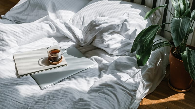 Person relaxing with coffee and newspaper at outdoor French cafe on sunny morning