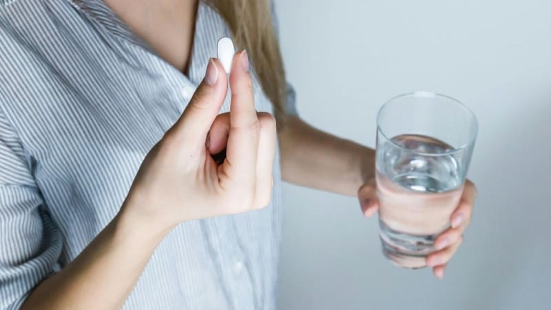 ** White medication pill on neutral background representing naltrexone addiction treatment breakthrough