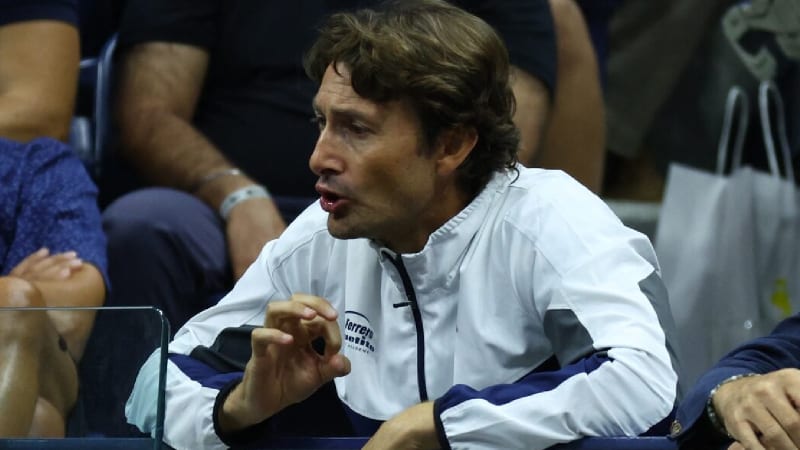 Juan Carlos Ferrero standing on golf course with golfer Angel Aroya during training session