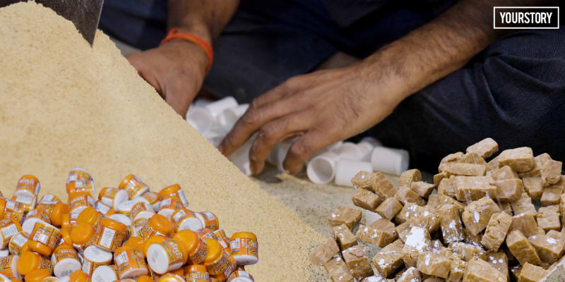 Worker packaging processed asafoetida spice in small pouches at Hathras processing facility in India