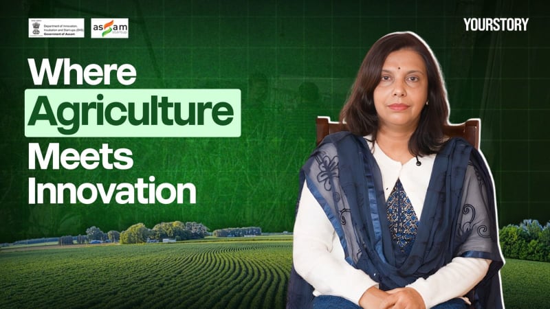 Female scientist in field examining crops with digital monitoring device in Assam India