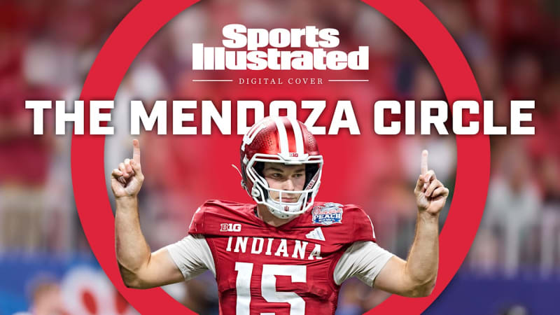 Indiana quarterback Fernando Mendoza holding Heisman Trophy in football uniform smiling