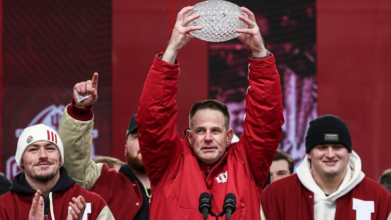 Indiana Hoosiers football players and coaches holding silver MacArthur Bowl trophy during championship celebration