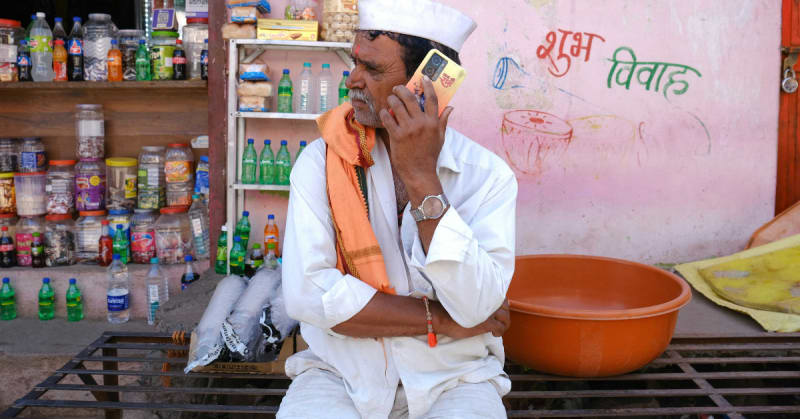 Indian farmer using smartphone in agricultural field to access farming guidance and advice