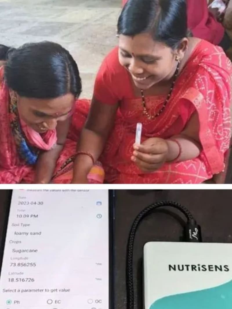 Farmer holding pocket-sized NutriSens soil testing device in agricultural field in India
