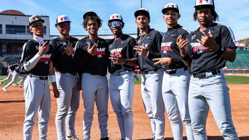 Young Black baseball players in uniform practicing pitching and catching at outdoor stadium