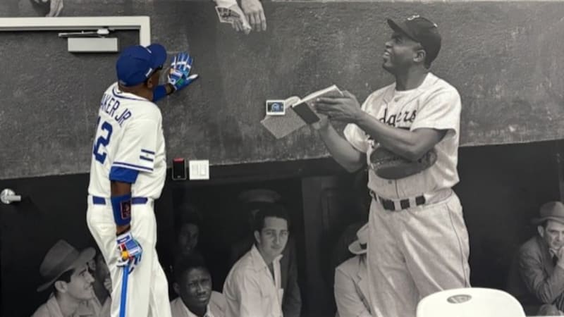 Dusty Baker standing in front of Jackie Robinson mural at historic Dodgertown training complex