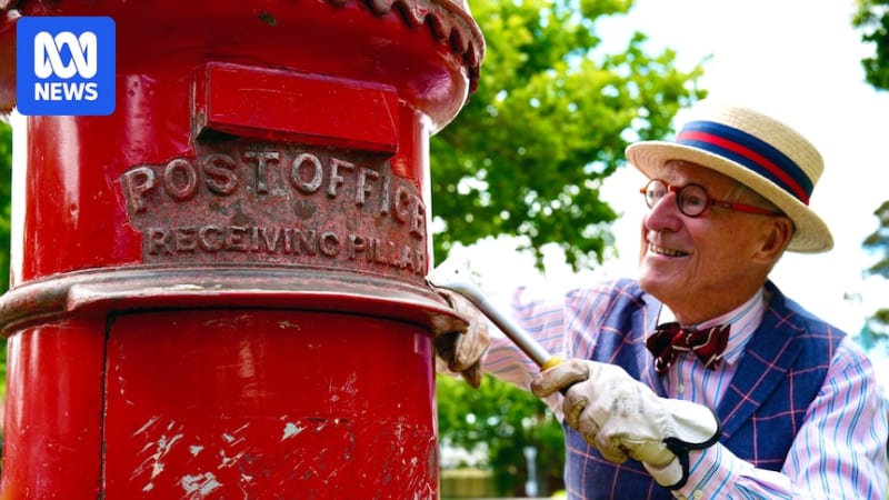 Elderly man in period costume restoring ornate red and gold Victorian-era pillar box on Melbourne street