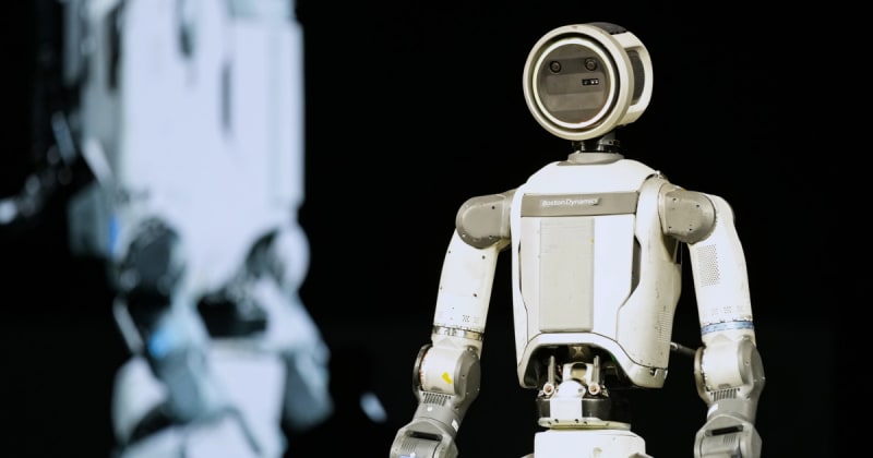 Boston Dynamics' humanoid robot Atlas standing on stage at CES, waving to audience during historic public debut