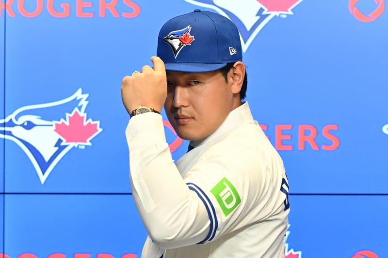 Baseball player Kazuma Okamoto smiling in Toronto Blue Jays uniform during press conference at Rogers Centre