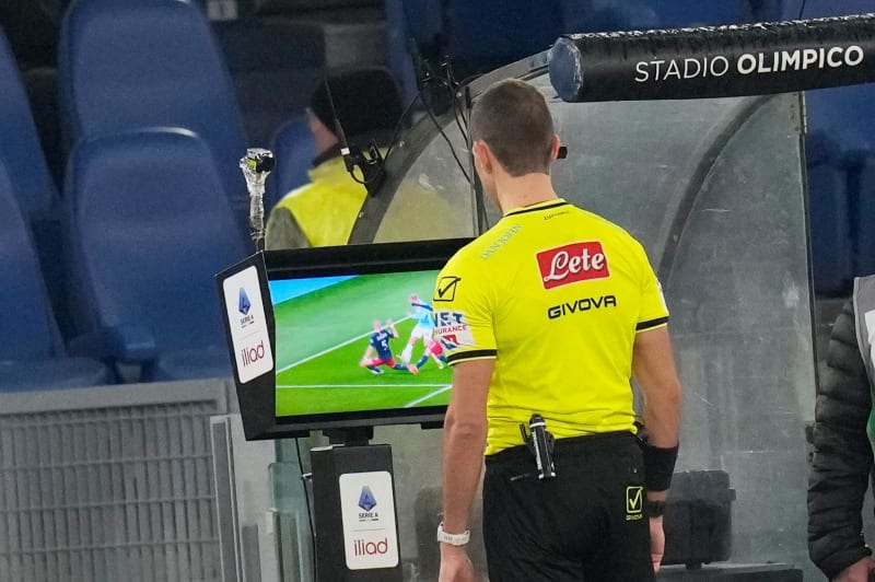 Soccer referee checking video review screen during professional match to ensure fair play