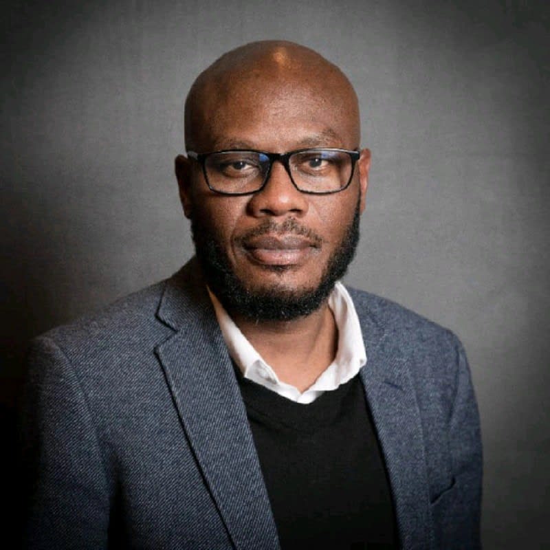 Healthcare workers in African clinic reviewing patient data on digital tablets together