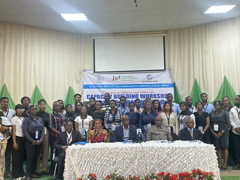 Young Nigerian scientists in white lab coats participating in pharmaceutical research training workshop