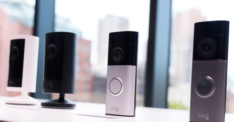 Ring doorbell camera mounted near home entrance with wildfire awareness notification displayed on smartphone screen nearby