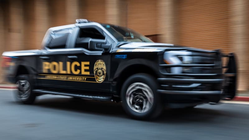 ASU police officer standing beside new electric Ford F-150 Lightning patrol truck on Tempe campus