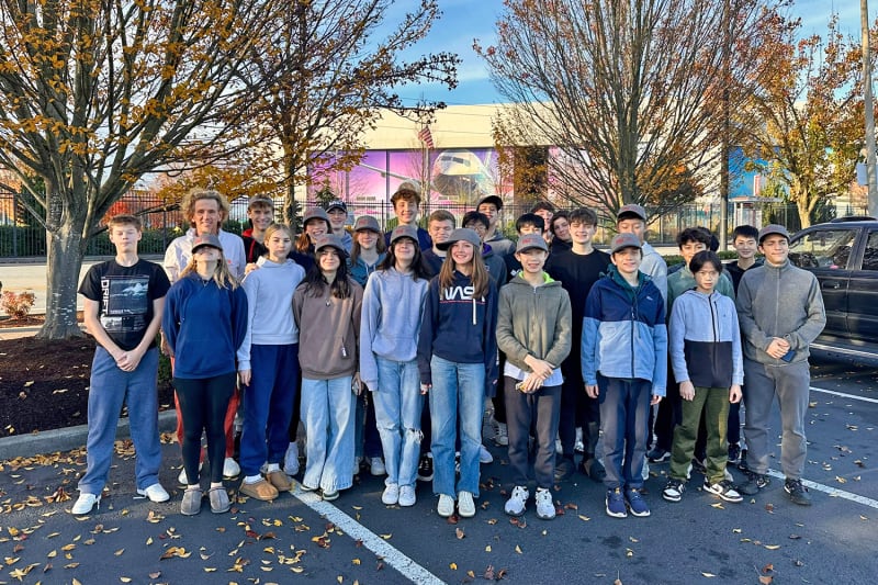 High school students touring Boeing 737 aircraft assembly facility with unfinished planes visible