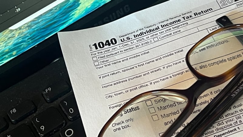 Volunteer tax preparer helps client complete tax return paperwork at community center desk