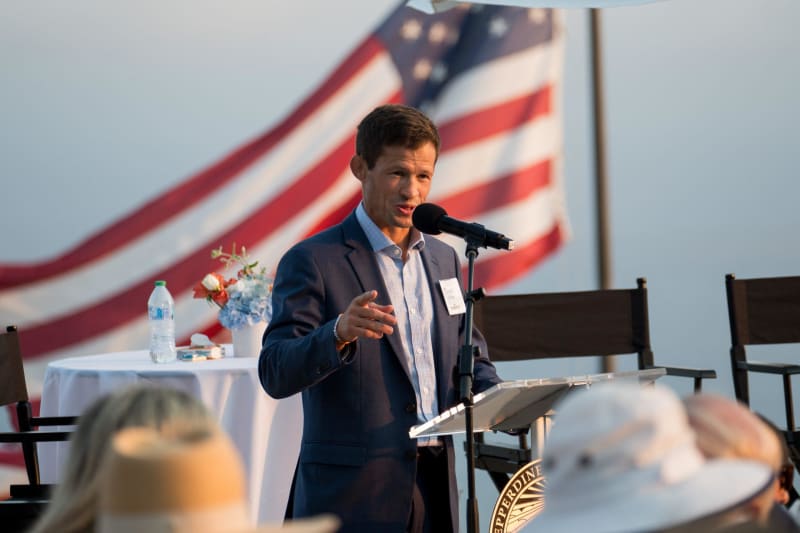 Pepperdine student-athlete standing at swimming pool, representing record-breaking academic and athletic achievement