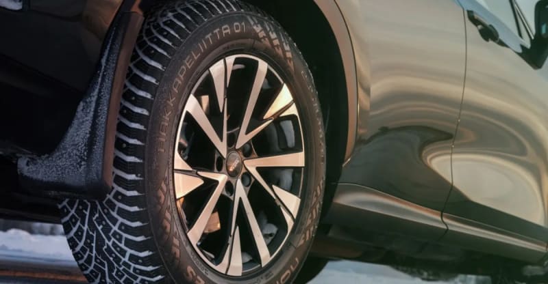Close-up cross-section of Nokian Hakkapeliitta tire showing retractable metal studs embedded in rubber