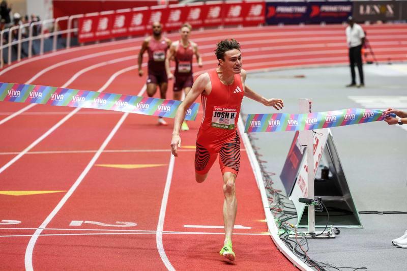 Josh Hoey celebrates with his brother Jaxson beside the digital record time display at Boston track