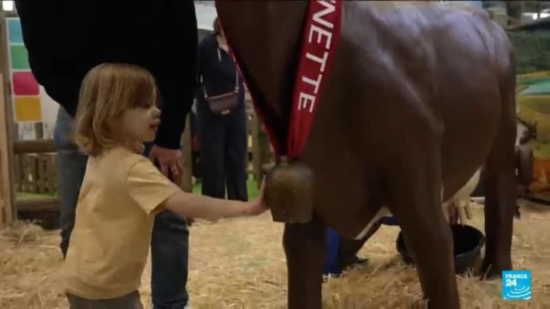 Children learning about farming from French farmers at agricultural exhibition in Paris