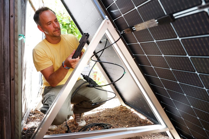 Bright Saver co-founder installing portable plug-in solar panels in Berkeley backyard