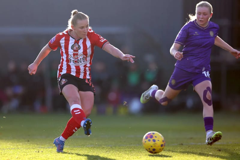 Sunderland AFC Women players celebrating at Eppleton Colliery Welfare Ground with supportive fans in background