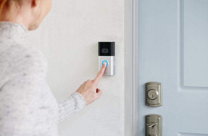 Ring video doorbell mounted on home exterior showing camera lens and motion sensor