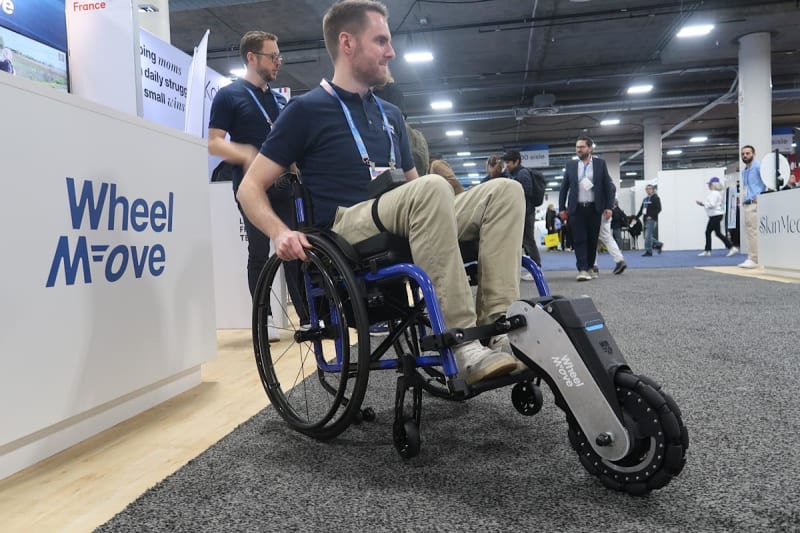 WheelMove motorized wheelchair attachment with large wheel helping user navigate outdoor terrain with ease and independence.