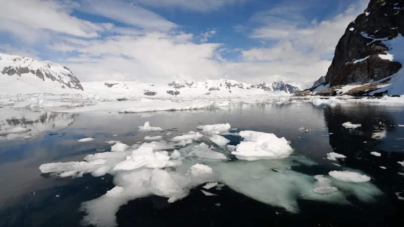 Antarctic ice sheet with blue ocean water showing layers of fresh meltwater mixing