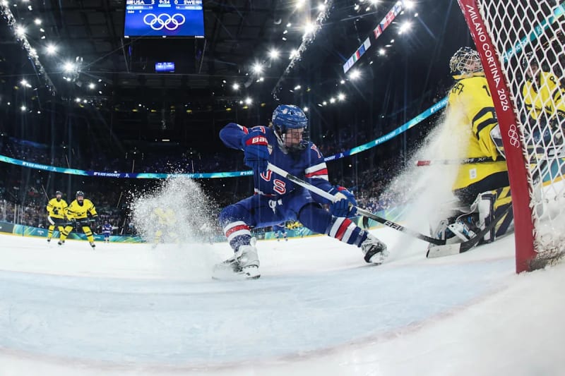 Team USA women's hockey players celebrate on ice after semifinal victory over Sweden