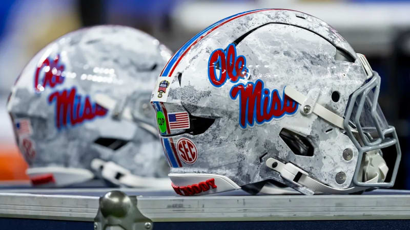 College football coaches reviewing game strategy on sideline during CFP playoff game preparation session