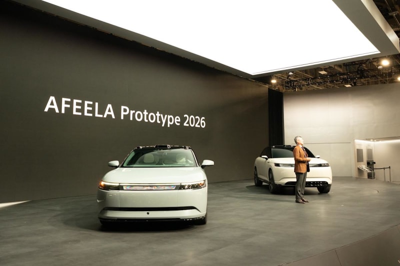Two Afeela electric vehicles displayed at CES trade show, showcasing sleek modern design with distinctive front LCD displays