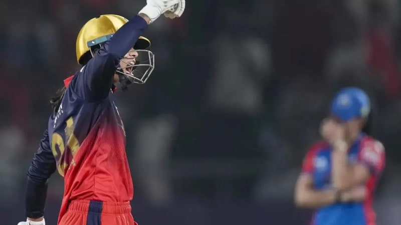 Smriti Mandhana celebrating with bat raised after leading RCB to WPL championship victory