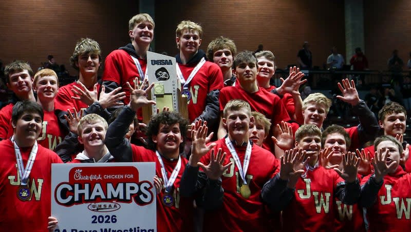 Juab High School wrestlers celebrating while holding up number tens after winning championship