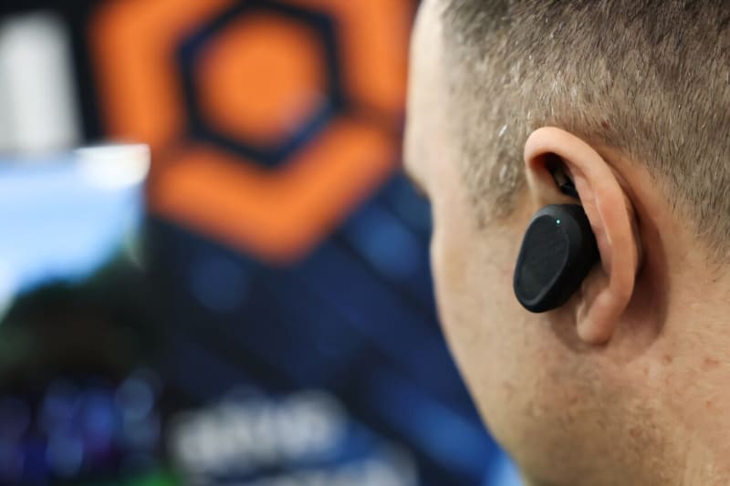 Modern wireless earbuds with AI sensors displayed at technology showcase, representing innovation in wearable tech
