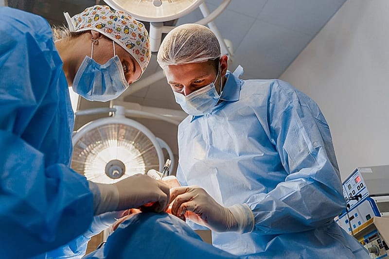 Medical professionals preparing donated organ for transplant in hospital operating room