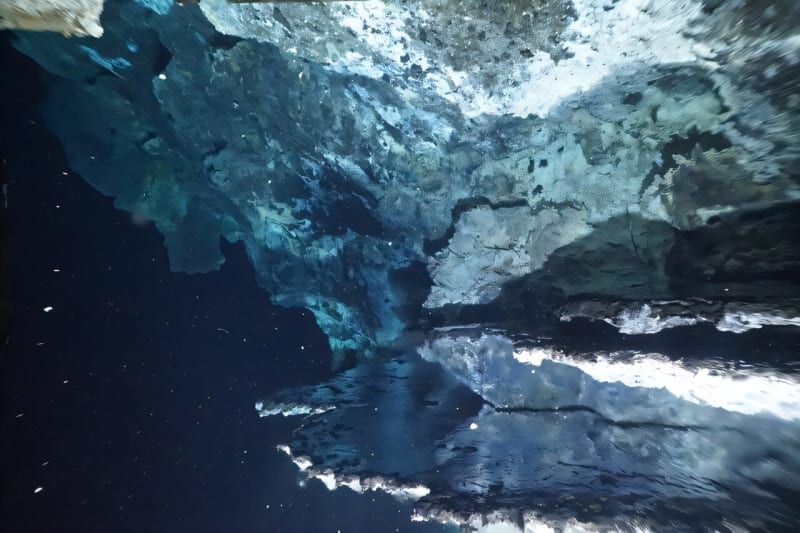 Shimmering hot hydrothermal fluid reflecting light under a vent flange on the deep ocean floor at Knipovich Ridge