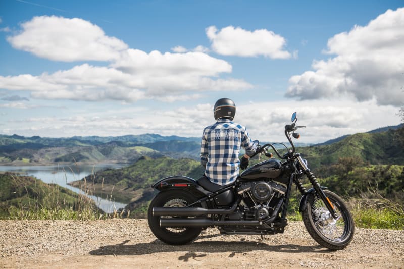 Motorcyclist riding on open road surrounded by nature, demonstrating mindful movement and focus