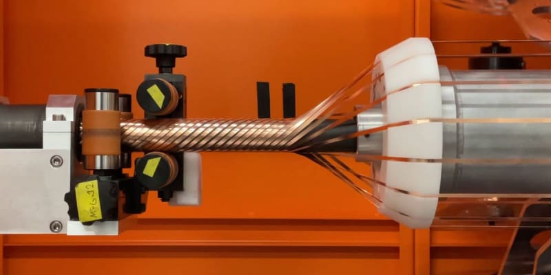 Engineer standing beside prototype server rack with superconducting power cables at Microsoft facility