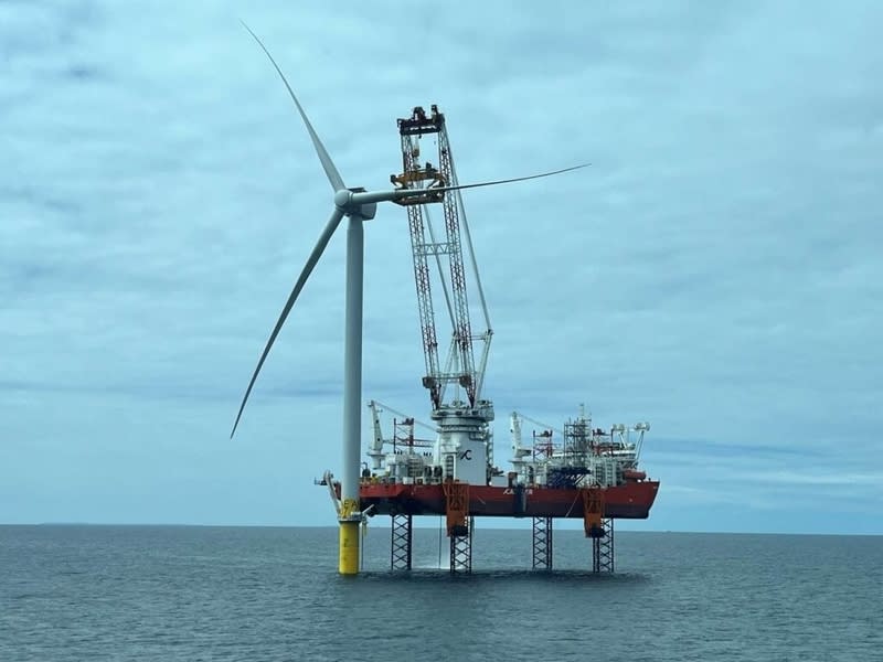 Offshore wind turbines rising from ocean waters near East Coast shoreline