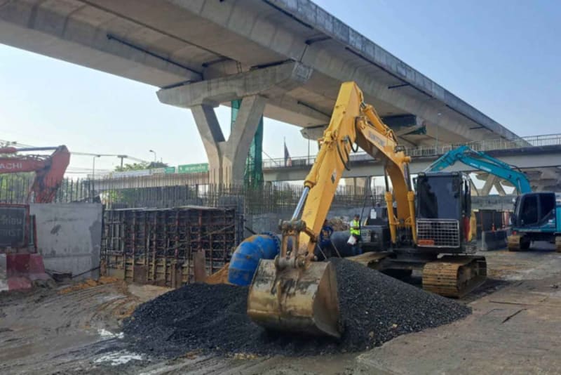 Construction equipment filling large sinkhole on Rama II Road in Samut Sakhon, Thailand