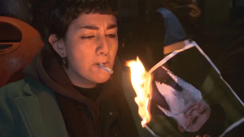 Protester holds burning image during rally supporting Iranian demonstrations in European city