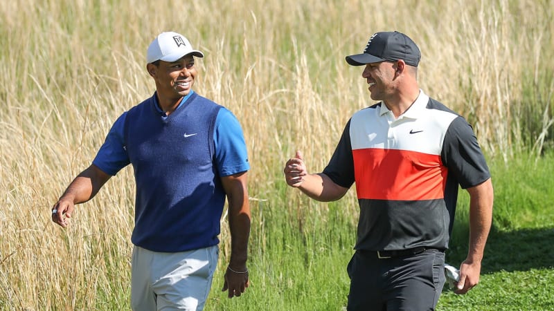Brooks Koepka and Tiger Woods walking together on golf course during tournament