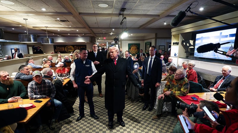 President Trump bowing his head in prayer with Iowa restaurant patron at Machine Shed