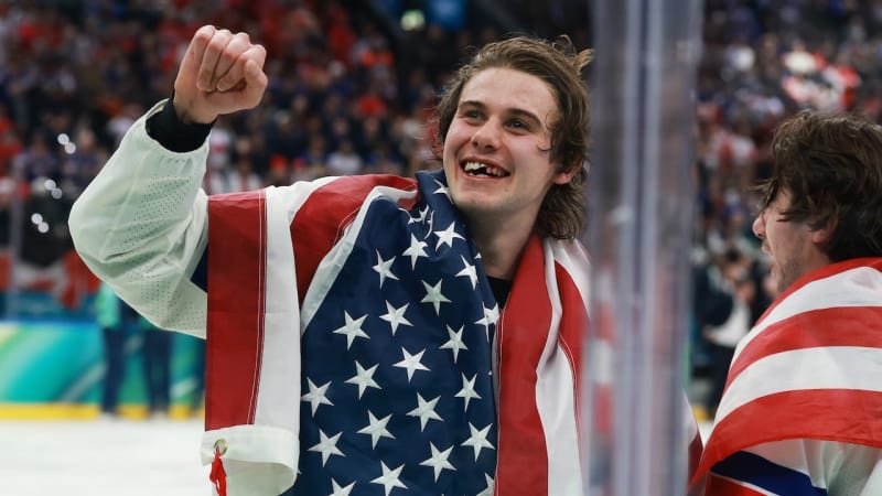 Jack Hughes celebrating in Team USA hockey jersey after scoring Olympic gold medal winning goal