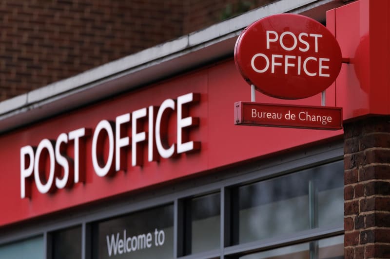 Traditional UK Post Office storefront serving customers on a busy high street