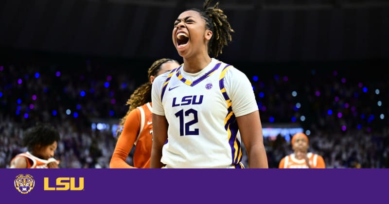 LSU women's basketball players celebrating victory over Texas in packed arena with fans cheering