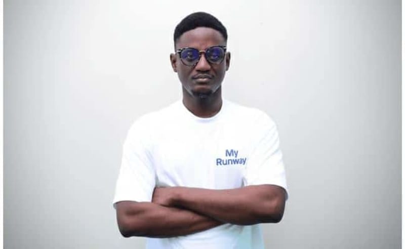 Young African professional using smartphone financial app with parent smiling nearby